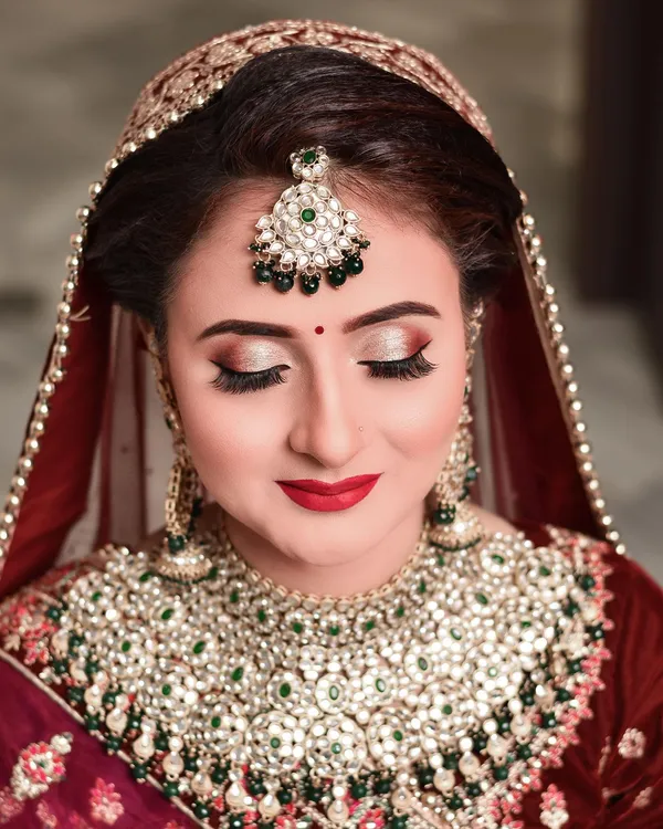 Detail of a layered kundan bridal necklace against a red lehenga