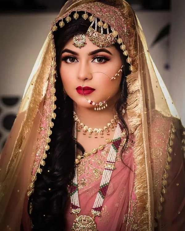 Bride in a pink and gold veil with traditional jewellery