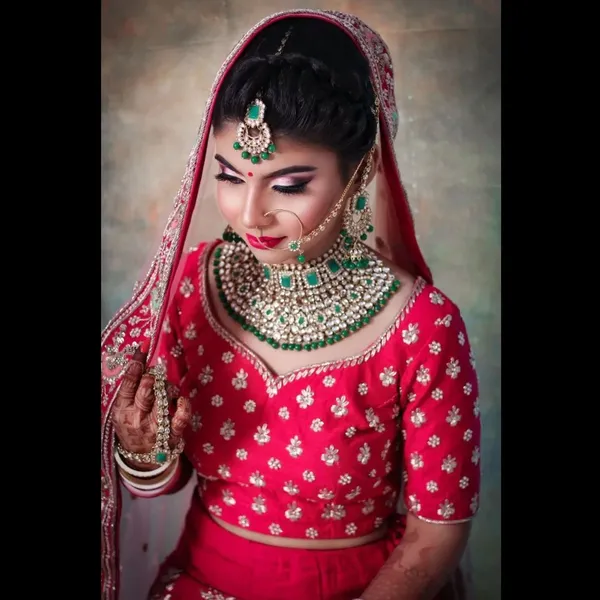Bride in pink and red with an emerald jewellery set