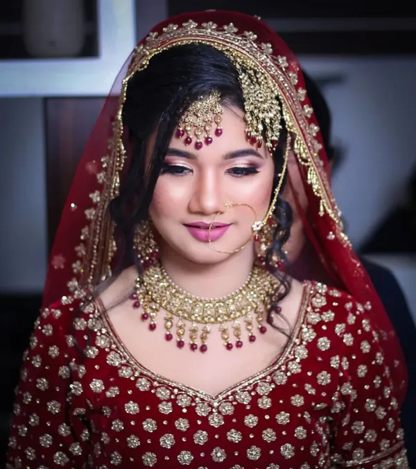 Bride under a red veil with kundan jewellery and a soft smoky eye