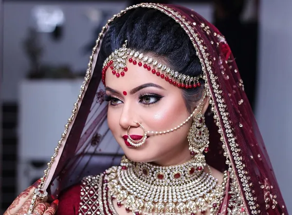 Close bridal portrait in a red lehenga with heavy kundan jewellery