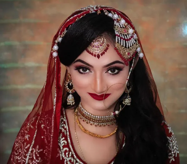 Bride in red and maroon with a bold lip and defined eye makeup