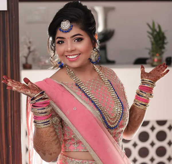Smiling bride-to-be in peach and pink with light engagement makeup